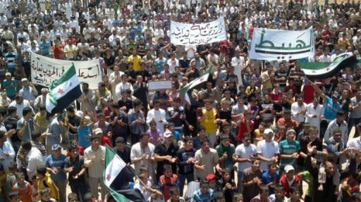 A image from the Syrian opposition Shaam News Network shows demonstrators waving pre-Baath flags at a rally in Habit in Idlib province on Friday. Worldwide anger grew on Saturday over the crackdown by Syrian President Bashar al-Assad's regime on a revolt in which more than 13,500 people, mostly civilians, have been killed since March 2011