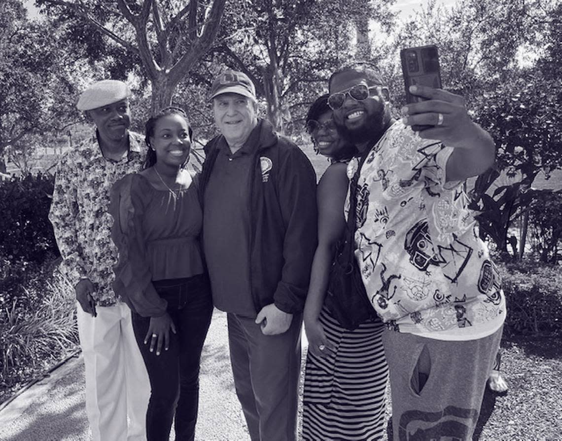 The commissioner, center, poses with tourists at Ferré Park in downtown Miami.