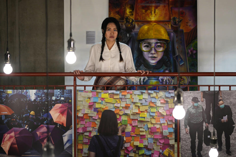 Exiled Hong Kong activist Carmen Lau who is acting in the play "May 35th", poses for a photograph besides the pictures depicting Hong Kong protest, in London, Thursday, May 30, 2024. As the 35th anniversary of Beijing's Tiananmen Square crackdown neared, Rowena He, a prominent scholar of the bloody chapter of modern China, was busy flying between the United States, Britain and Canada to give a series of talks. Each was aimed at speaking out for those who cannot. (AP Photo/Kin Cheung)