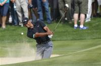 Tiger Woods of the U.S. hits the ball out of the bunker on the third hole during the second round of the 2014 Omega Dubai Desert Classic in Dubai January 31, 2014. REUTERS/Ahmed Jadallah