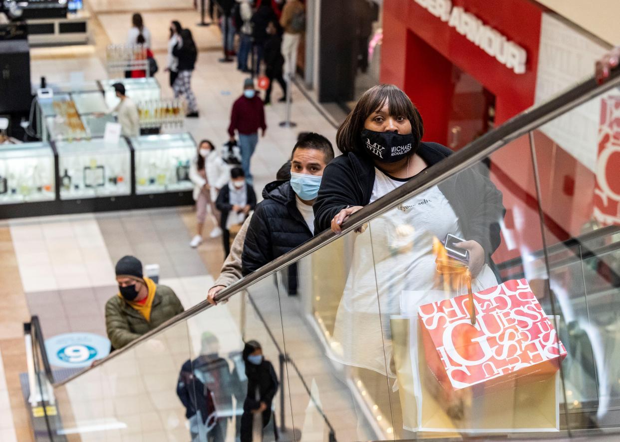 A customer carries her purchases during Black Friday shopping on Nov. 26, 2021. (Photo by Joel Lerner/Xinhua via Getty Images)