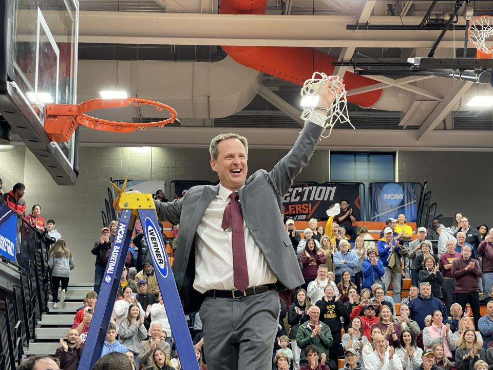 Gannon University women's basketball coach Cleve Wright hoists the net after it was cut down to celebrate Gannon's victory over Fayetteville State in the Atlantic Region final March 19 at the Hagerty Family Events Center.