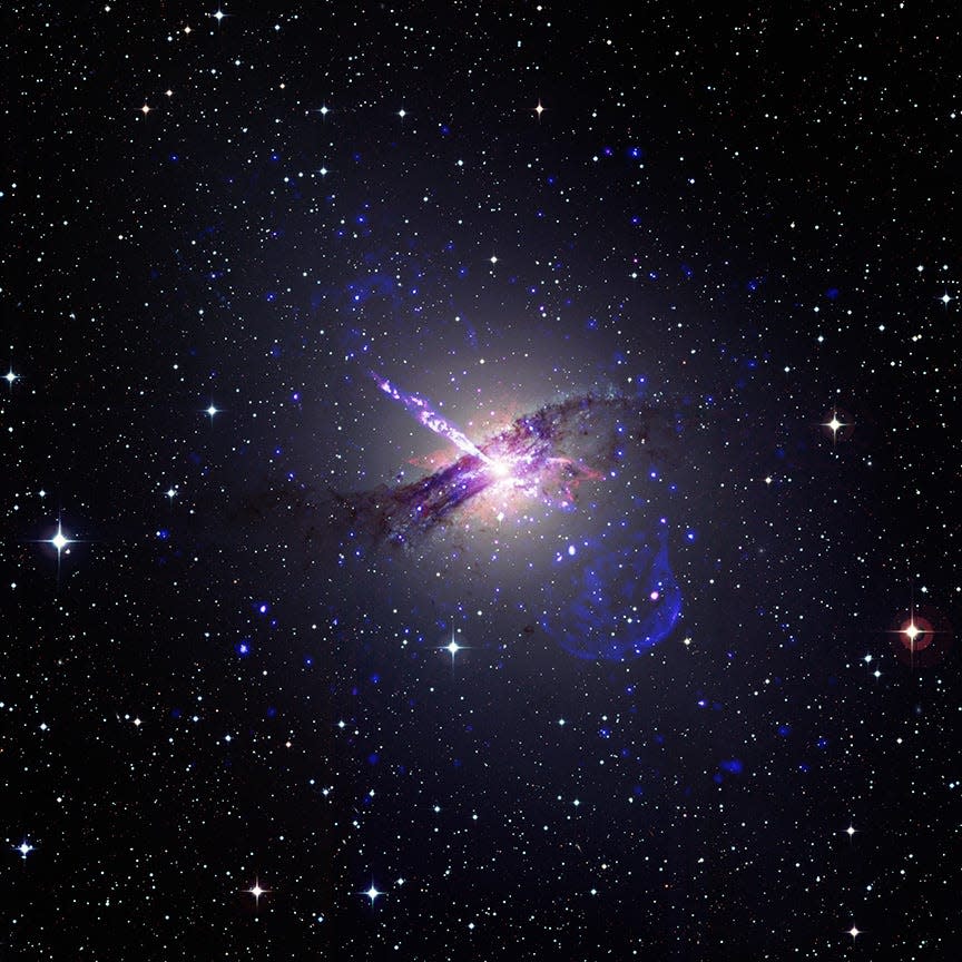faint dark purple swirl in space with a bright jet shooting out of its center