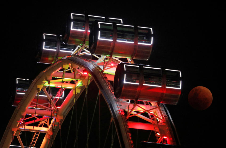 <p>The moon is seen during an eclipse, next to the Singapore Flyer observation wheel in Singapore, Jan. 31, 2018. (Photo: Edgar Su/Reuters) </p>