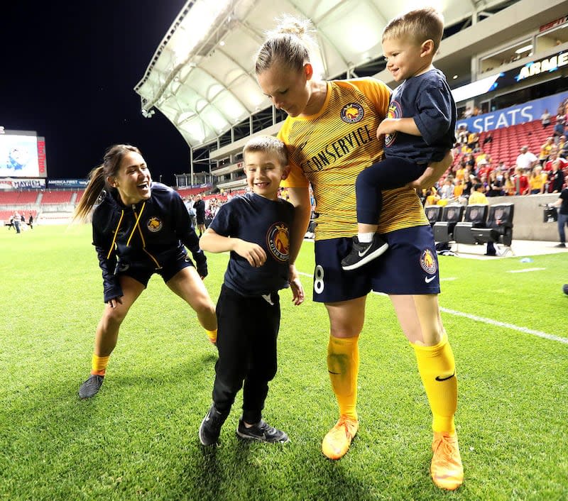 Utah Royals FC forward Amy Rodriguez (8) gathers her sons Ryan and Luke as teammate Lo'eau LaBonta (9) plays with them after a match against the Orlando Pride at Rio Tinto Stadium in Sandy on Wednesday, May 9, 2018. | Scott G Winterton, Deseret News