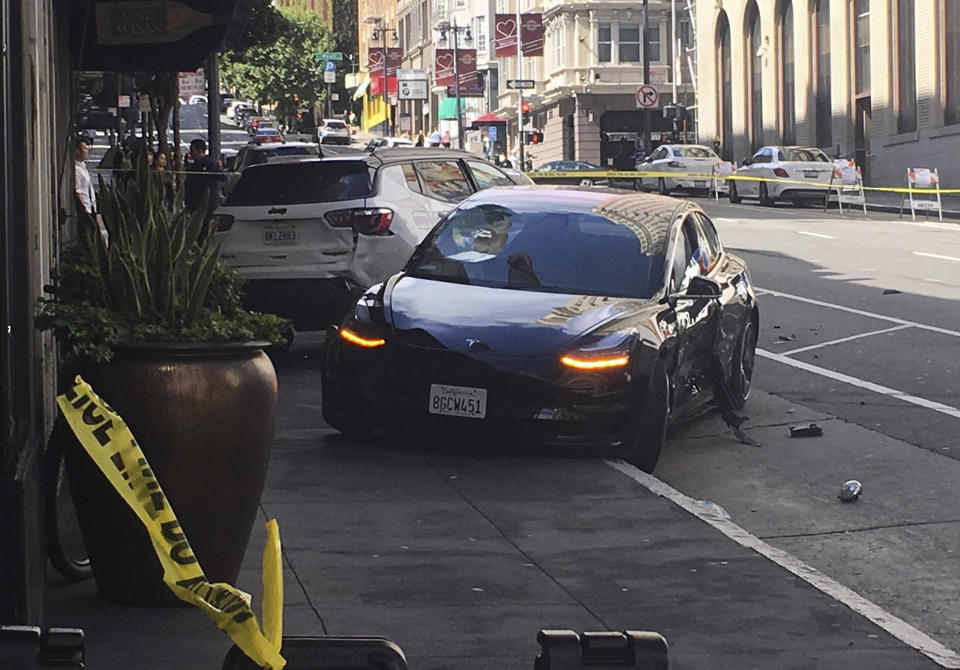 This photo taken Sunday, July 21, 2019, and provided by KGO-TV shows the scene after a woman was arrested after running a red light in a rented Tesla in San Francisco and causing a crash that killed a tourist and left his wife critically injured. Officers were investigating whether the Tesla, which was rented through the peer-to-peer car rental service Get Around, was operating on self-driving mode, police said in a statement Monday, July 22, 2019. (Kate Larsen/KGO-TV via AP)