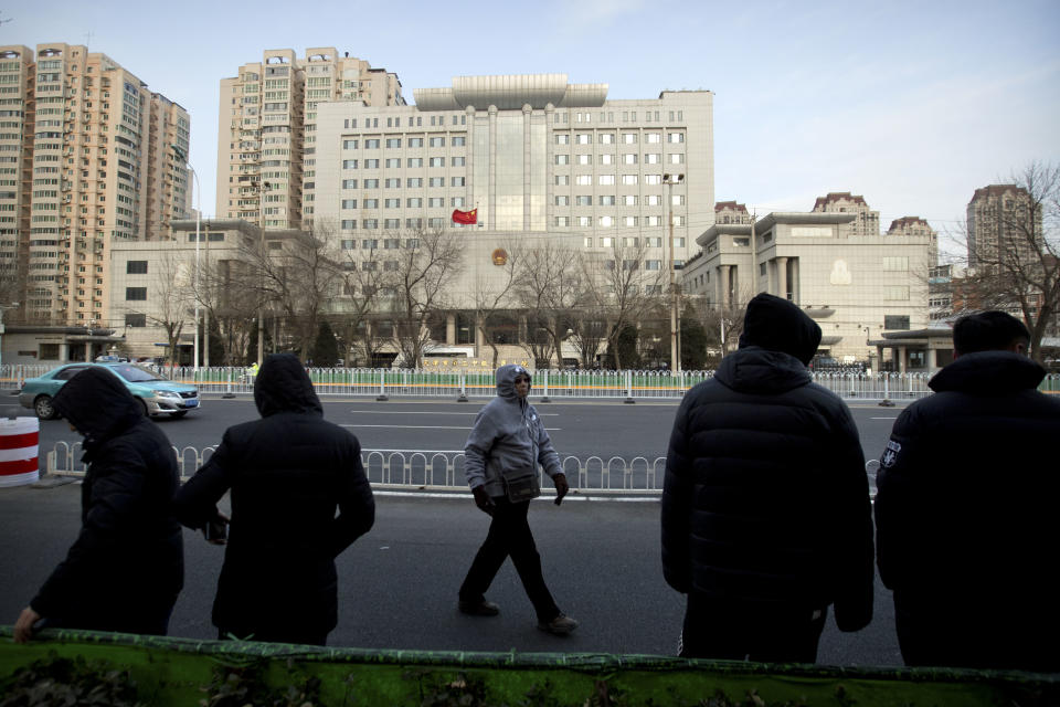 Plainclothes security officers stand in the street opposite the Secondary Intermediate People's Court of Tianjin northeastern China's Tianjin municipality, Wednesday, Dec. 26, 2018. The trial of Chinese human rights lawyer Wang Quanzhang, who was charged with subversion of state power in 2016, was expected to begin at the court on Wednesday morning. (AP Photo/Mark Schiefelbein)