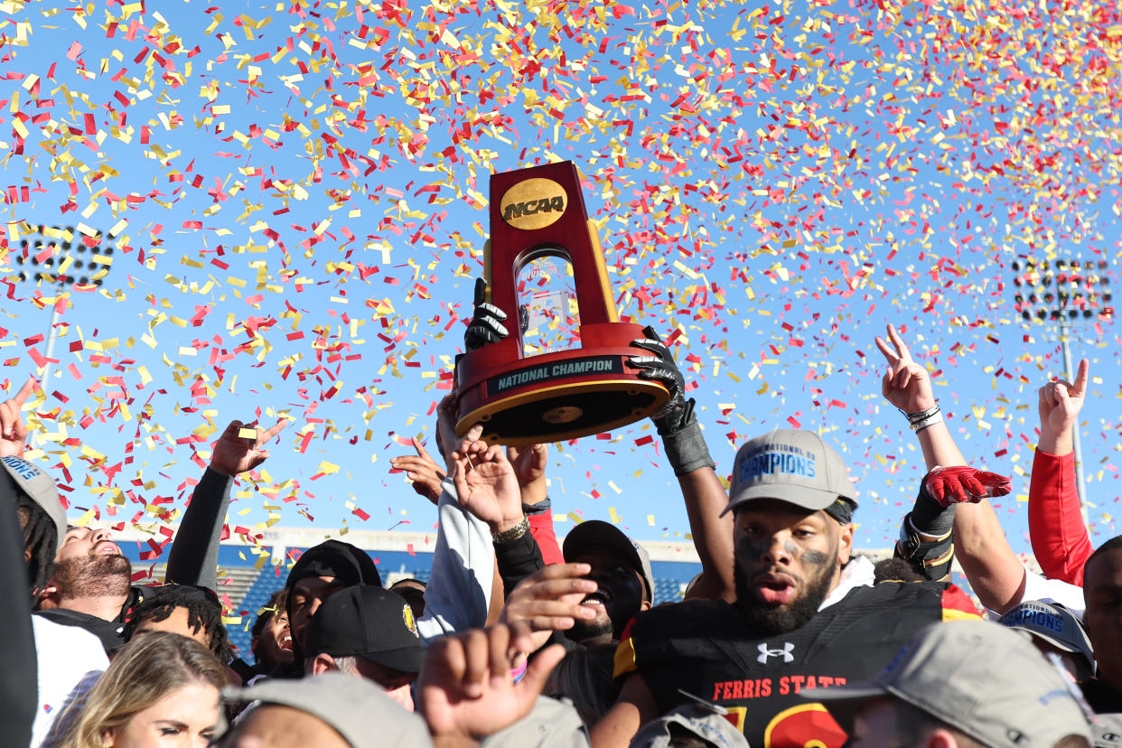 MCKINNEY, TX - DECEMBER 17: Ferris State Bulldogs players hold up the championship trophy after winning the game against the Colorado School of Mines Orediggers during the Division II Football Championship held at McKinney ISD Stadium on December 17, 2022 in McKinney, Texas. (Photo by Tim Heitman/NCAA Photos via Getty Images)
