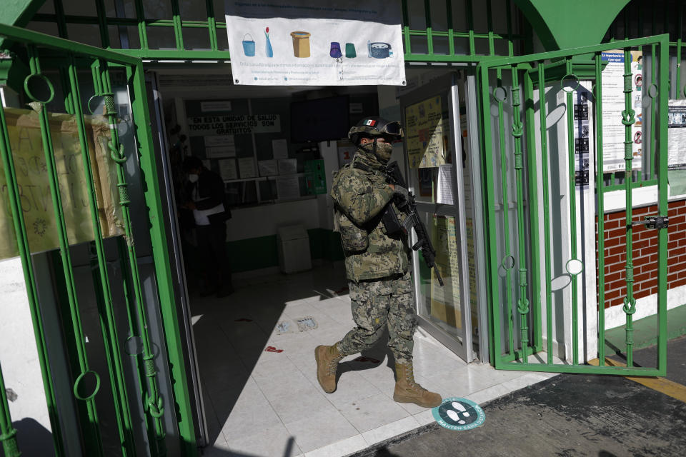 A soldier walks out of a health center where people over age 60 are being given the AstraZeneca vaccine for COVID-19 as Mexico begins vaccinating its elderly population against the new coronavirus in the outlying Milpa Alta borough of Mexico City, Monday, Feb. 15, 2021. (AP Photo/Rebecca Blackwell)