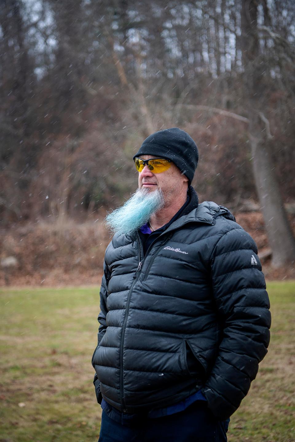 Lane Wyatt’s family property is seen on the hill behind him in Woodfin as sleet falls, December 6, 2023.