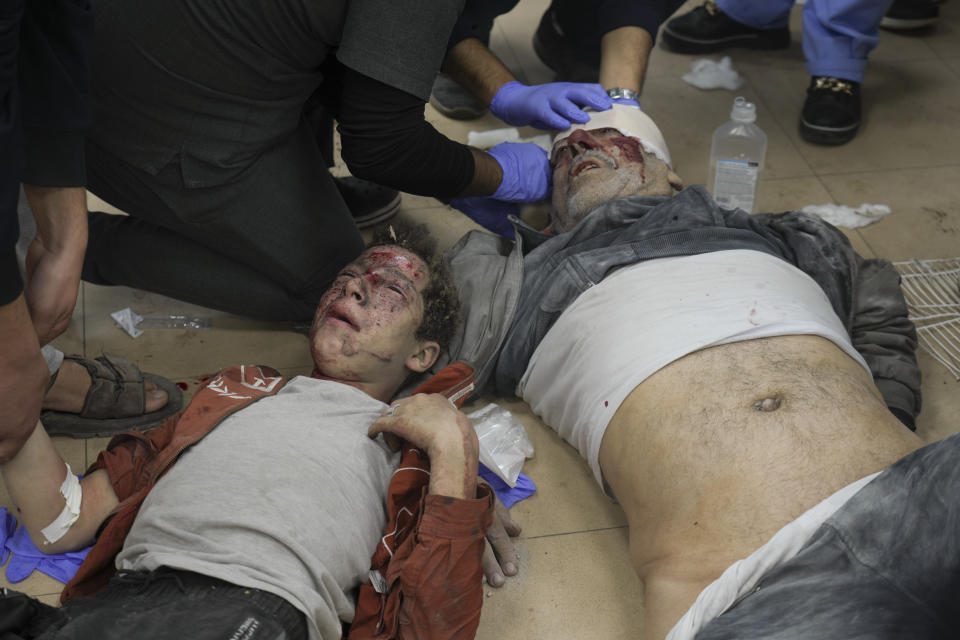 Palestinians wounded in Israeli bombardment are helped in a hospital in Deir al Balah, Monday, Jan. 1, 2024. (AP Photo/Hatem Moussa)