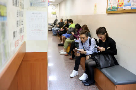 Du Yueting, 42, and her girlfriend Zhang Tongyu (R), 35, wait at a Chinese medicine clinic in Taoyuan, Taiwan, November 20, 2018. REUTERS/Ann Wang
