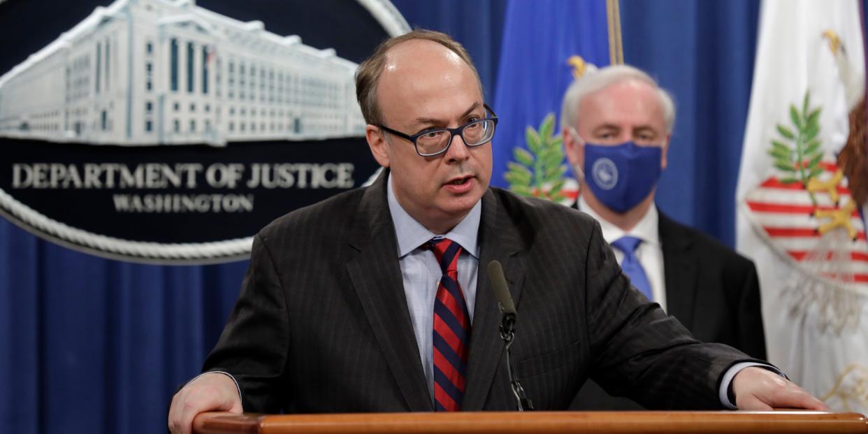 Jeffrey Clark stands at a DOJ podium.