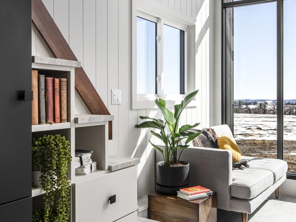 the couch next to large windows and the staircase