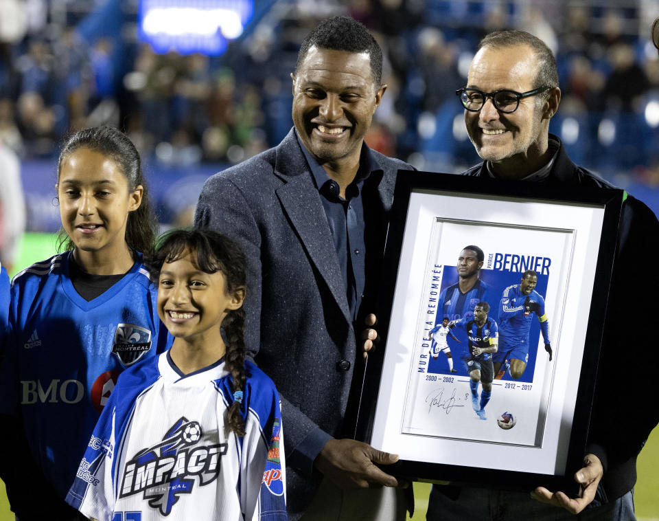 CF Montreal chairman Joey Saputo, right, presents Patrice Bernier with a plaque as he is inducted into the club's hall of fame, during an MLS soccer game in Montreal, Saturday, May 6, 2023. (Allen McInnis/The Canadian Press via AP)