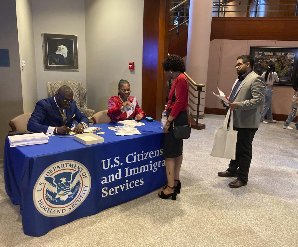 Candidates for U.S. citizenship check in at The Carter Center, Sunday, Oct. 1, 2023, in Atlanta, for their naturalization ceremony. The event included 99 new citizens to mark former President Jimmy Carter's 99th birthday. The new Americans came from 45 countries. (AP Photo/Bill Barrow)