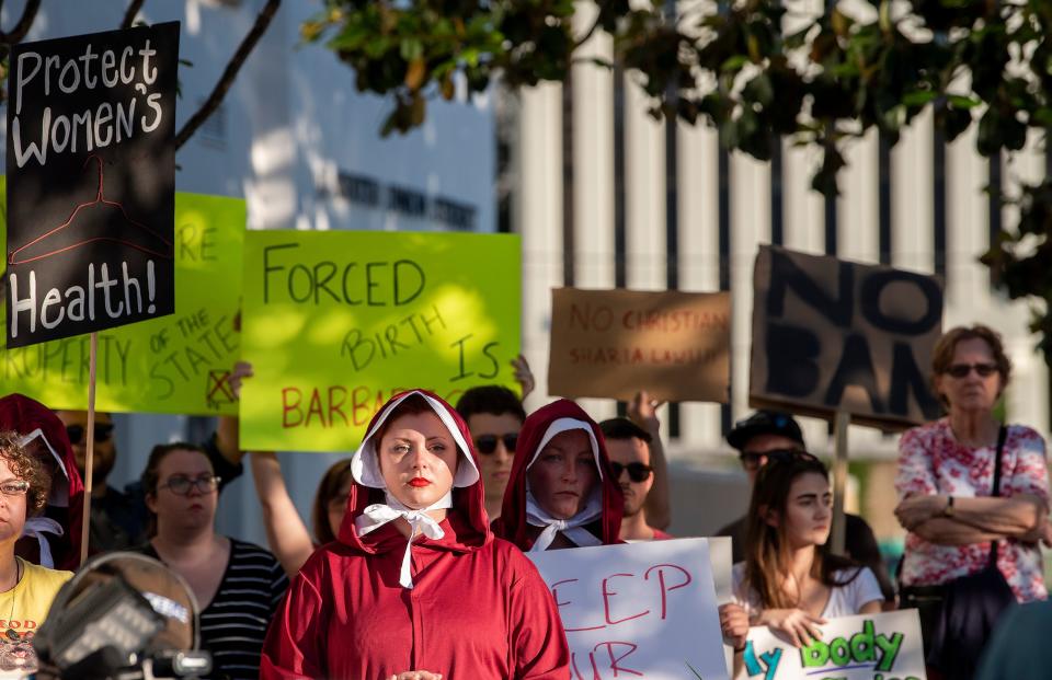 Margeaux Hartline, dressed as a handmaid, protests against a ban on nearly all abortions outside of the Alabama State House in Montgomery, Ala., on May 14, 2019.