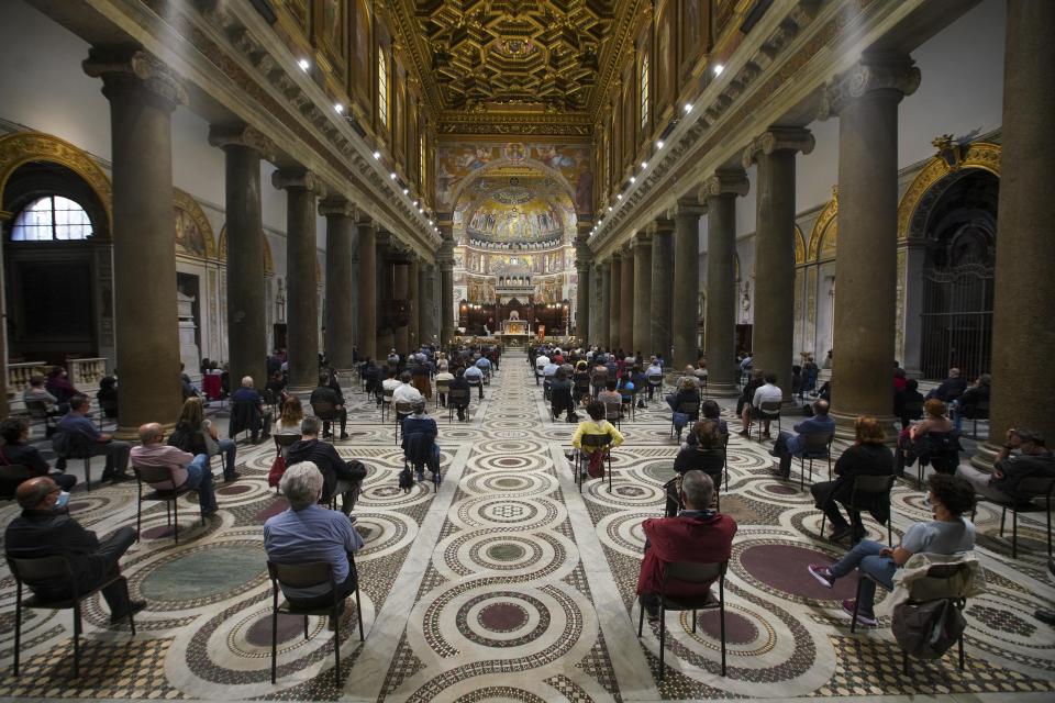 Faithful are seated according to social distancing measures as they attend a vigil prayer lead by US Cardinal Kevin Joseph Farrell over the death of George Floyd, a black man who died after being restrained by Minneapolis police officers on May 25, in Rome's Santa Maria in Trastevere church, Friday, June 5, 2020. Cardinal Farrell says the killing of George Floyd has laid bare that the Christian principles of the U.S. Constitution aren’t being applied to blacks, and is evidence that divisive, demonizing language can kill. (AP Photo/Andrew Medichini)