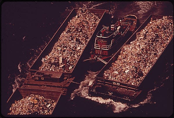 PART OF THE 26,000 TONS OF SOLID WASTE THAT NEW YORK CITY PRODUCES EACH DAY. TUGS TOW HEAVILY-LADEN BARGES DOWN THE EAST RIVER TO THE OVERFLOWING STATEN ISLAND LANDFILL