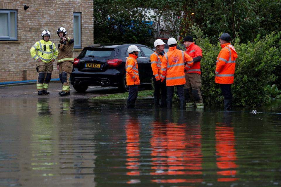 Firefighters and water utilities workers are seen dealing with flooding in Hemel Hempstead (REUTERS)