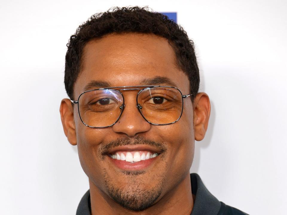 A headshot of Curtis Hamilton smiling and wearing sunglasses in front of a white background.