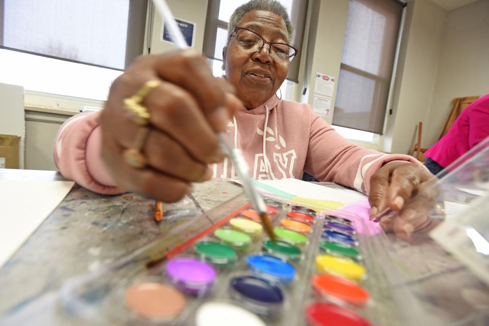 Creola Bragg paints with watercolors Friday morning during the Caregiver Appreciation Event at the Richland Academy of the Arts.