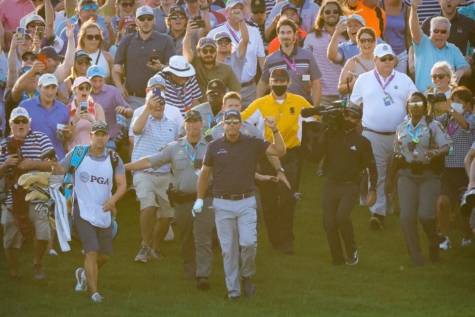 Phil Mickelson and caddie Tim Mickelson walk to the 18th green during the final round of the PGA Championship.