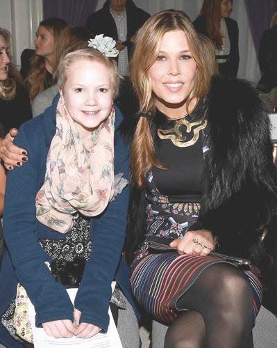 A young Olivia Stern smiles with Mary Alice Stephenson, the National Fashion Ambassador for Make-a-Wish, at the Marchesa Fashion Show.