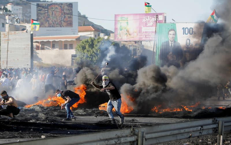 Un palestino usa una honda durante una protesta contra Israel por la violencia transfronteriza entre militantes palestinos en Gaza y el ejército israelí, cerca del puesto de control de Hawara cerca de Naplusa en la Cisjordania ocupada por Israel