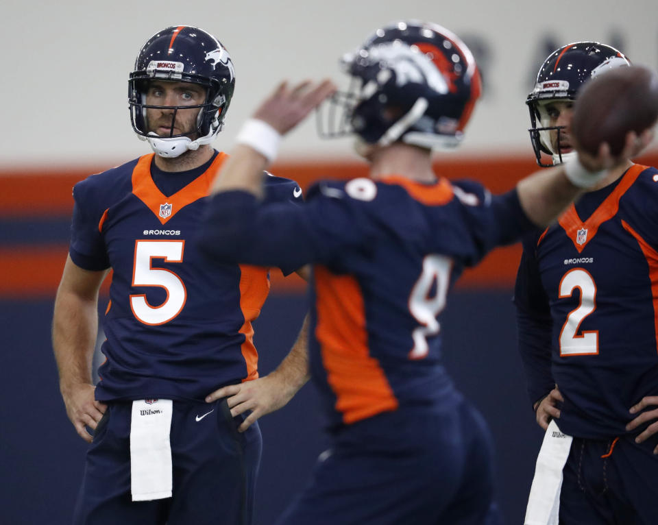 Denver Broncos quarterback Joe Flacco, left, watches as quarterback Kevin Hogan throws during the NFL football team's veterans minicamp Tuesday, April 16, 2019, in Englewood, Colo. (AP Photo/David Zalubowski)