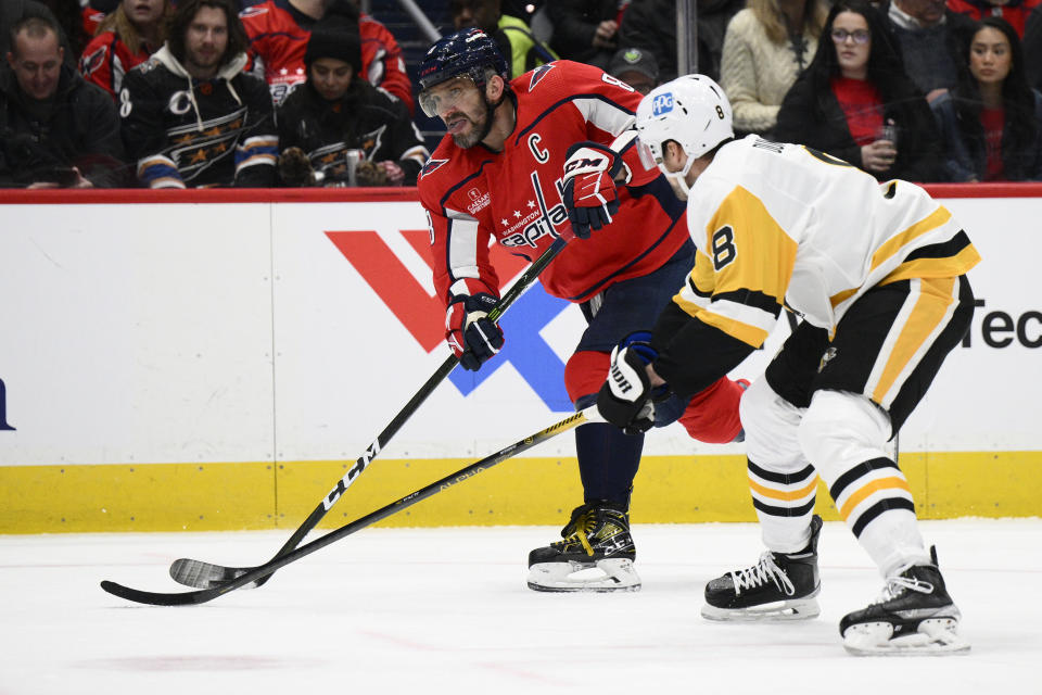 Washington Capitals left wing Alex Ovechkin, back, skates with the puck against Pittsburgh Penguins defenseman Brian Dumoulin during the first period of an NHL hockey game Thursday, Jan. 26, 2023, in Washington. (AP Photo/Nick Wass)