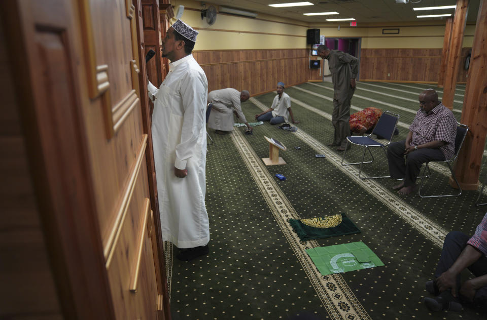 A member of the Abubakar As-Saddique Islamic Center recites the Islamic call to prayer, or adhan, on Thursday, May 12, 2022, in Minneapolis. The adhan exhorts men to go to the closest mosque five times a day for prayer, which is one of the Five Pillars of Islam. Abubakar, which hosts some 1,000 men for Friday midday prayers, plans to hold meetings with neighbors before publicly broadcasting publicly the call this summer. (AP Photo/Jessie Wardarski)