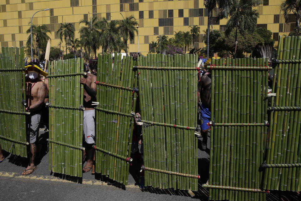 Indigenous with bamboo shields line up outside Congress in Brasilia, Brazil, Tuesday, June 22, 2021. Indigenous are camping in the capital to oppose a proposed bill they say would limit recognition of reservation lands. (AP Photo/Eraldo Peres)