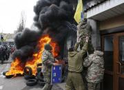 Servicemen from the Aydar battalion throw a Ukrainian flag from the building of Ukraine's Defence Ministry, during a protest against the disbanding of the battalion, in Kiev, Ukraine, in this February 2, 2015 file photo. REUTERS/Valentyn Ogirenko/Files