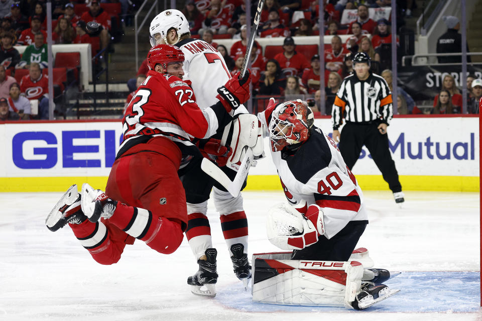 Carolina Hurricanes' Stefan Noesen (23) collides with New Jersey Devils' Dougie Hamilton (7) while trying to dive out of the way of the puck in front of New Jersey Devils goaltender Akira Schmid (40) during the second period of Game 5 of an NHL hockey Stanley Cup second-round playoff series in Raleigh, N.C., Thursday, May 11, 2023. (AP Photo/Karl B DeBlaker)