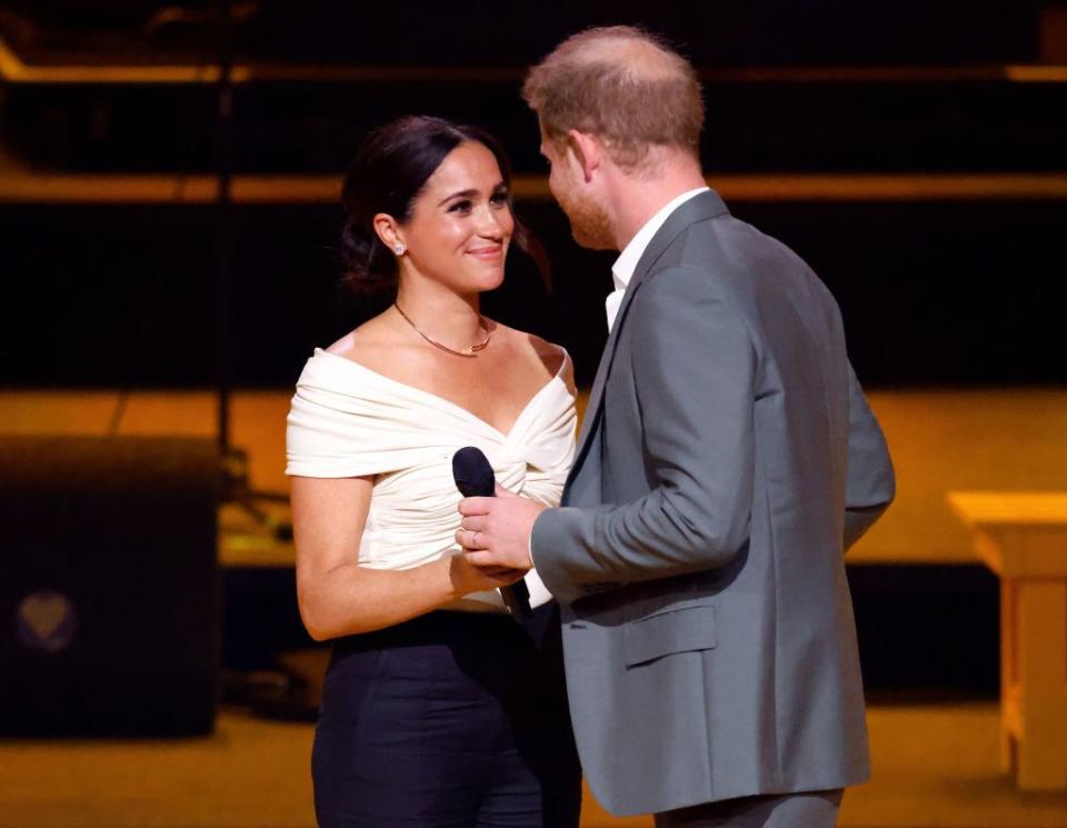 meghan markle and prince harry on stage of invictus games opening cermony, meghan looking at harry smiling