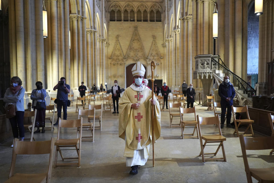 Bishop of Lyon Emmanuel Gobilliard leads mass, the first since lockdown restrictions were introduced to curb the spread of the coronavirus, at the Saint-Jean Cathedral, in Lyon, central France, Saturday, May 23, 2020. France allowed religious services to resume Saturday after a legal challenge to the government's ban on such gatherings. (AP Photo/Laurent Cipriani)