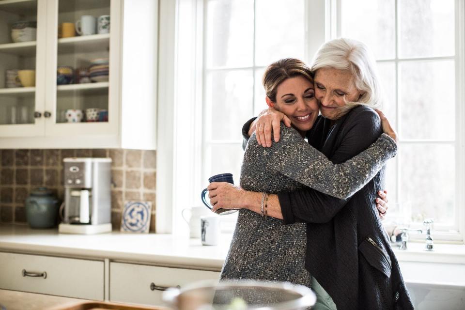 mother and daughter hugging in kitchen