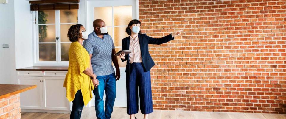 Real estate agent and customer in face mask looking at a new project