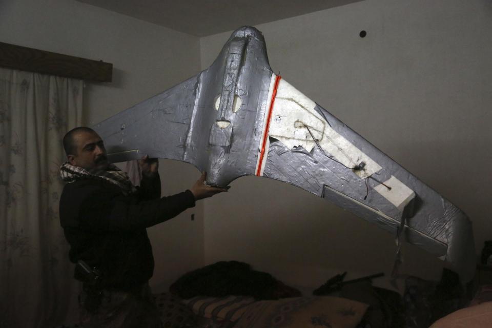 In this Friday, Jan. 27, 2017 photo, an Iraqi officer holds a drone belonging to Islamic State militants in Mosul, Iraq. Islamic State is hacking store-bought drone technology, using rigorous testing and tactics that mimic those used by U.S. unmanned aircraft to adapt to diminishing numbers of fighters and a battlefield that is increasingly difficult to navigate on the ground. (AP Photo/Khalid Mohammed)