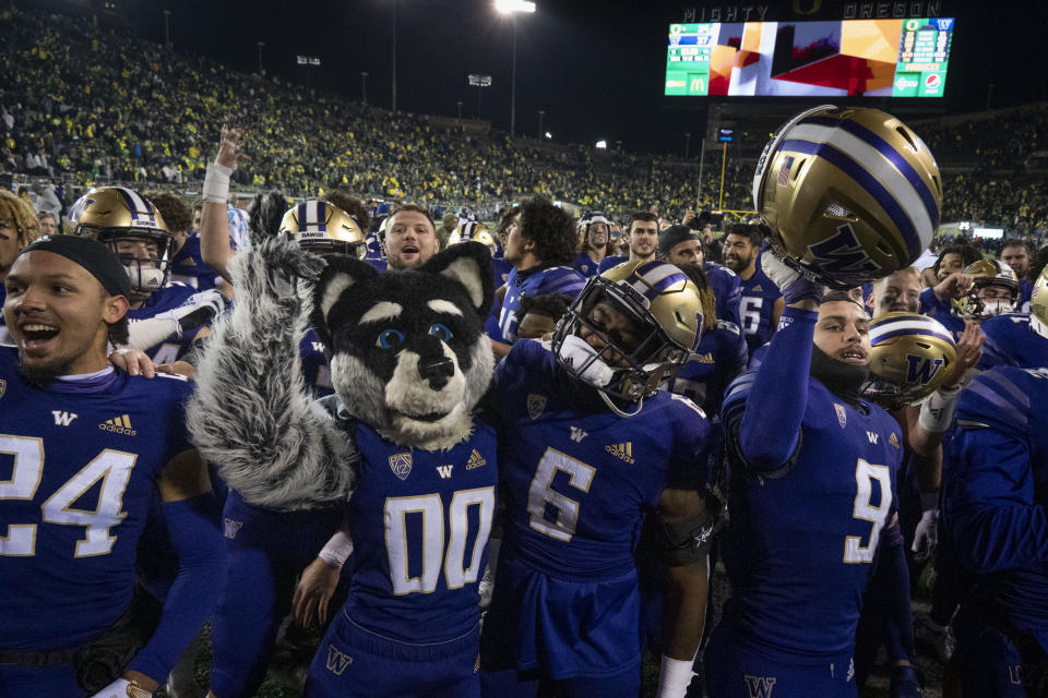 Washington players and their mascot celebrate after defeating Oregon in an NCAA college football game Saturday, Nov. 12, 2022, in Eugene, Ore. . (AP Photo/Andy Nelson)