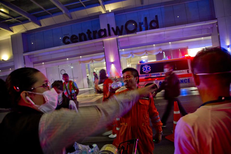 A firefighter drinks water outside the scene of a fire at the Central World mall in Bangkok, Thailand, Wednesday, April 10, 2019. A fire has broken out at in the major mall complex in Thailand's capital, with initial reports from Thai emergency services saying the fire has caused fatalities. (AP Photo/Gemunu Amarasinghe)