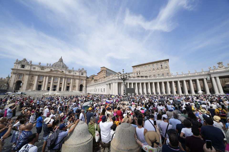 People gather in St.Peter's Square at the Vatican as Pope Francis recites the Angelus noon prayer from the window of his studio, Sunday, Aug. 27, 2023. (AP Photo/Andrew Medichini)