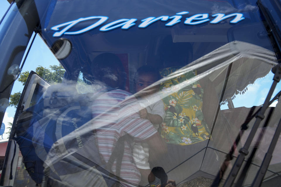 Migrants, many from from Haiti, board a bus that will transport them to another shelter on their journey through Panama, trying to reach the United States, in Lajas Blancas, Darien province, Panama, Friday, Oct. 1, 2021. (AP Photo/Arnulfo Franco)