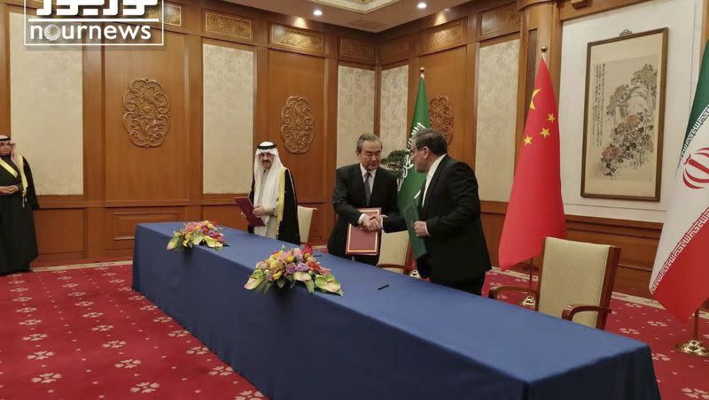 In this photo released by Nournews, Secretary of Iran’s Supreme National Security Council, Ali Shamkhani, right, shakes hands with China’s most senior diplomat Wang Yi, as Saudi Arabia’s National Security Adviser Musaad bin Mohammed al-Aiban looks on during an agreement signing ceremony between Iran and Saudi Arabia to reestablish diplomatic relations and reopen embassies after seven years of tensions between the Mideast rivals, in Beijing, China, Friday, March 10, 2023. 