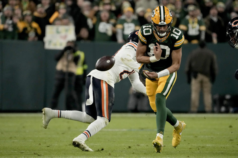 Green Bay Packers quarterback Jordan Love (10) fumbles after being hit by Chicago Bears cornerback Tyrique Stevenson, left, during the second half of an NFL football game Sunday, Jan. 7, 2024, in Green Bay, Wis. The Bears recovered the fumble. (AP Photo/Morry Gash)