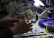 A money changer counts U.S. dollar bills at a currency exchange in Manila January 15, 2014. REUTERS/Romeo Ranoco