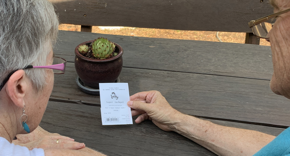 An elderly couple holding a lottery ticket, as its announced there will now be another weekly lottery draw. 