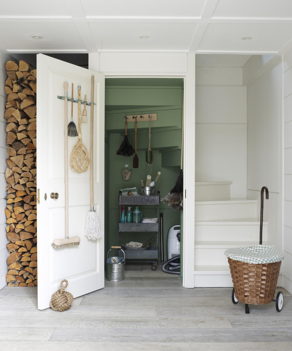 An under stairs idea with a green painted cleaning cupboard