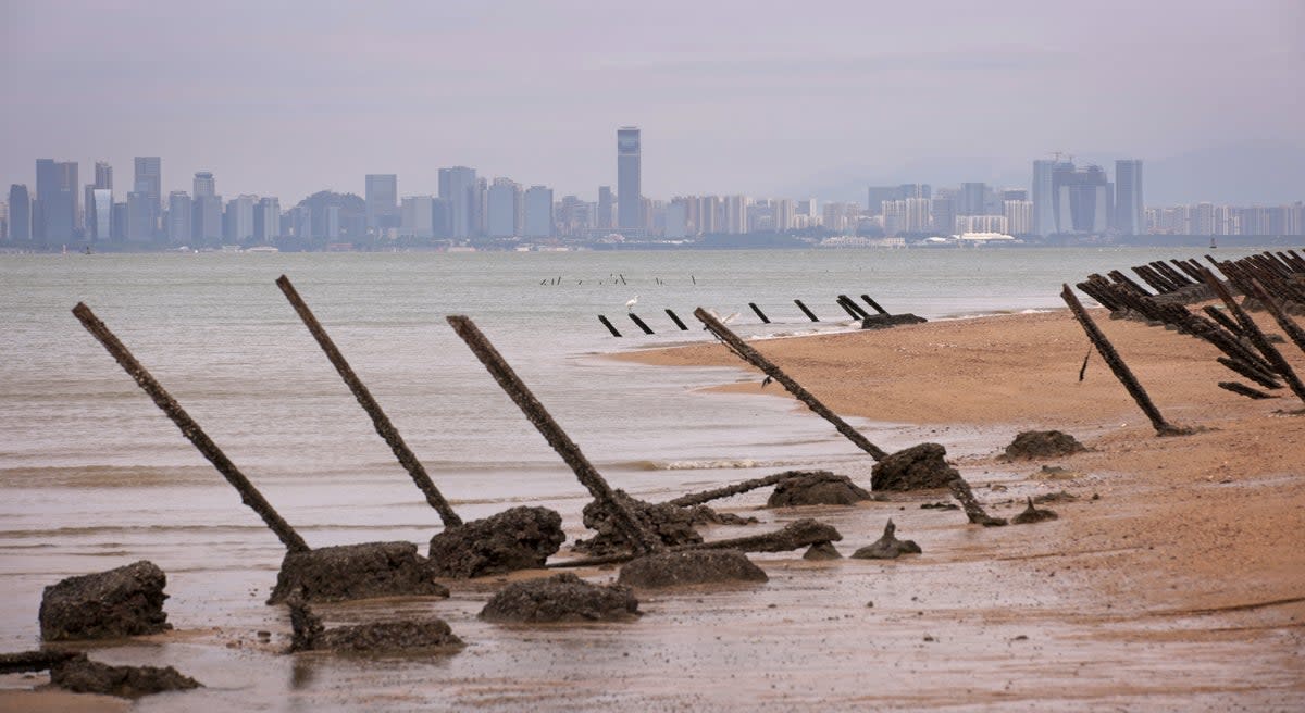 As the city of Xiamen, China, is seen in the background, wartime anti-tank obstacles sit on a beach on October 7, 2023 in Kinmen, Taiwan (Getty Images)